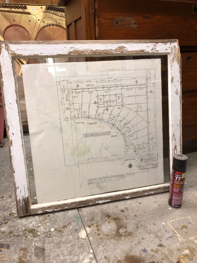 Use spray adhesive to mount vintage blueprints in an old window frame. An easy DIY project from thejunkparlor.com