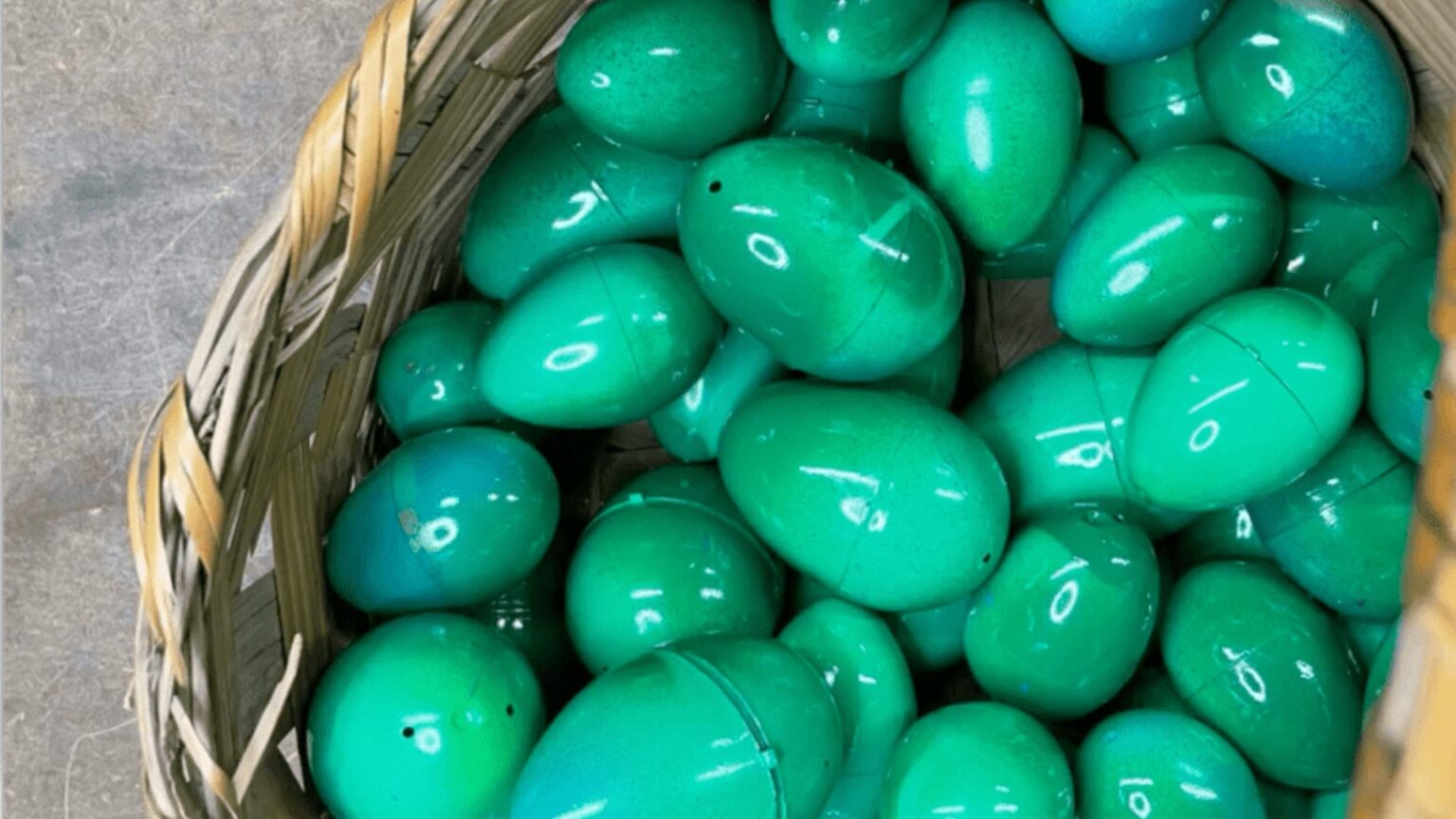 Basket of green and blue spray painted plastic Easter eggs