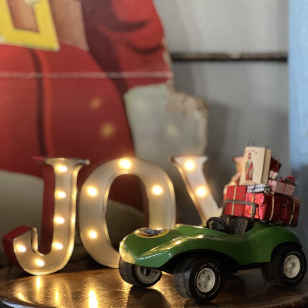 View of the toy car with presents and Joy in the background.