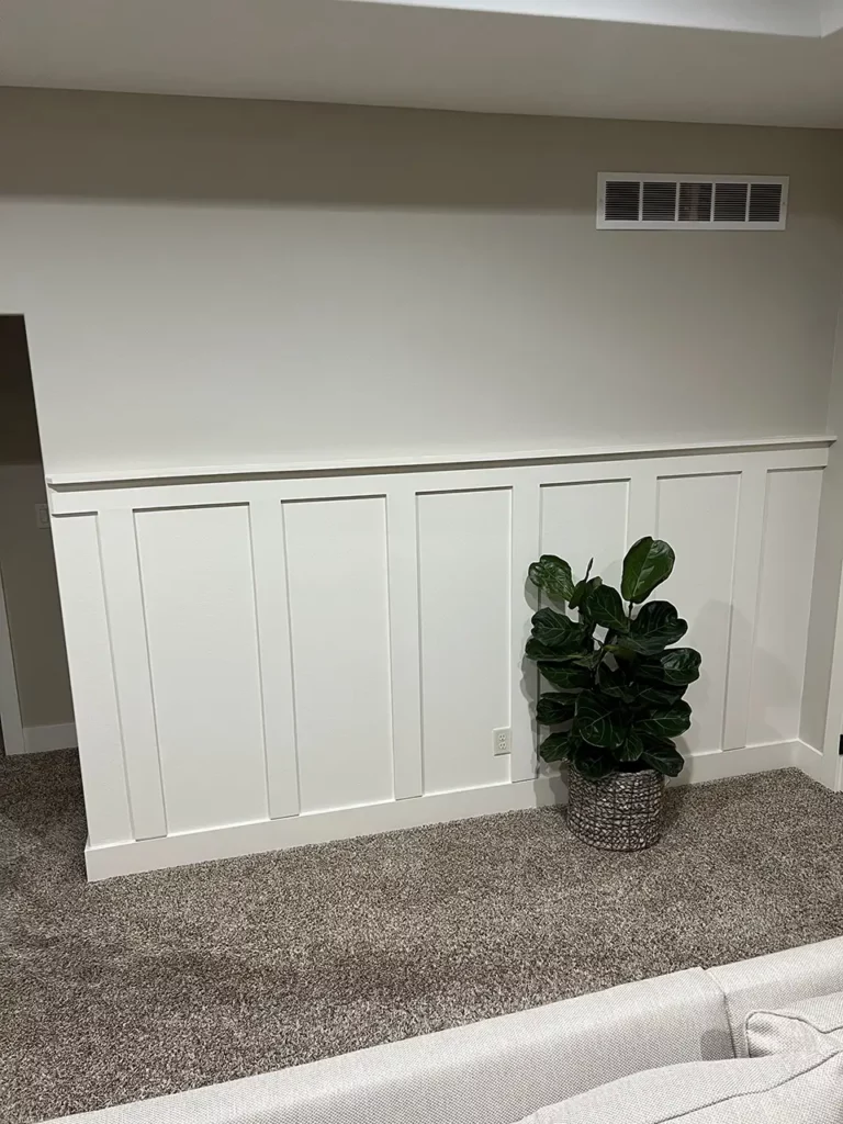 Potted fiddle leaf in front of the board and batten wall.