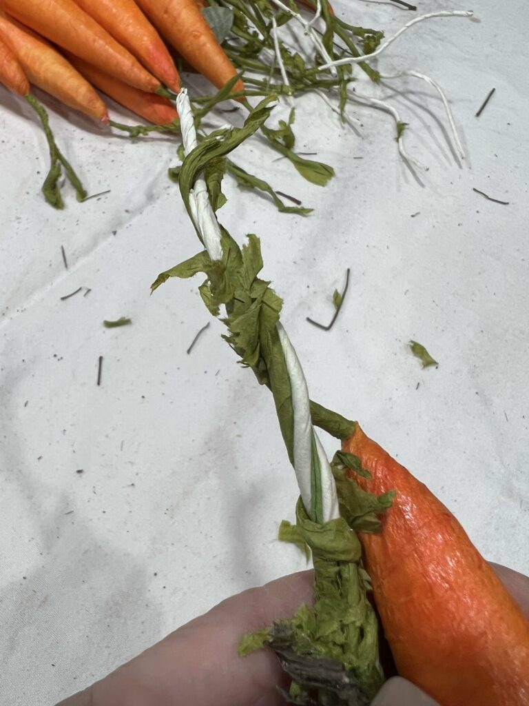 Twisting the carrot stems together.