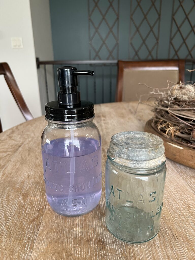 View of one mason jar being repurposed into a soap dispenser and another with an old galvanized lid