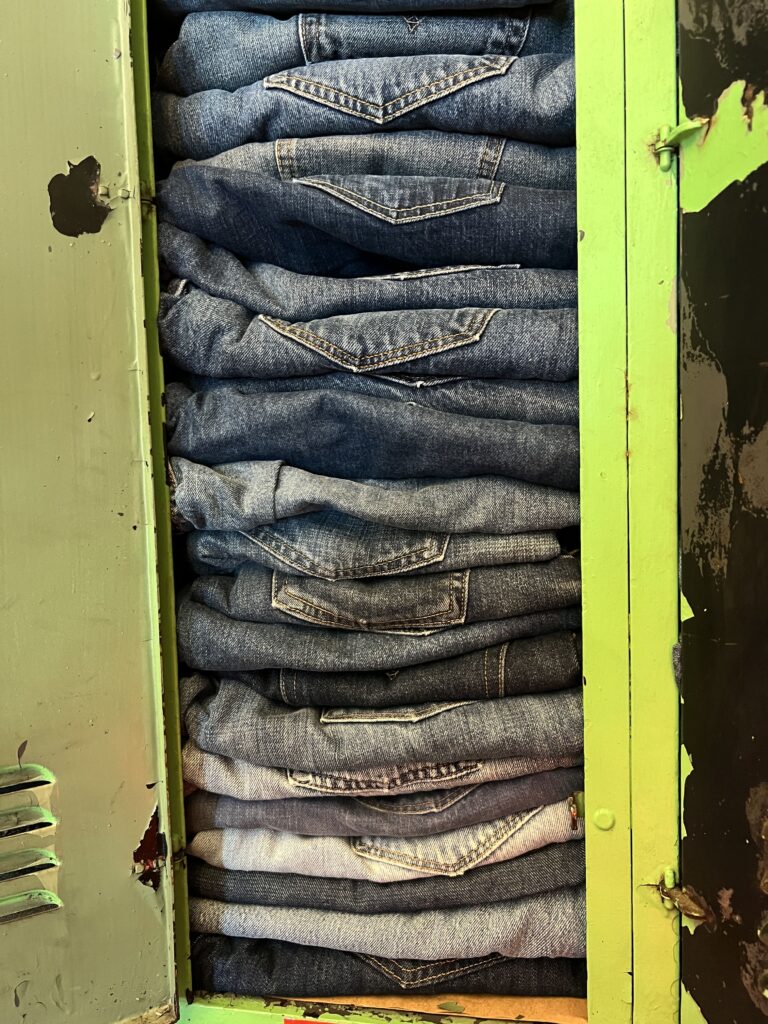 stack of blue jeans in an old locker