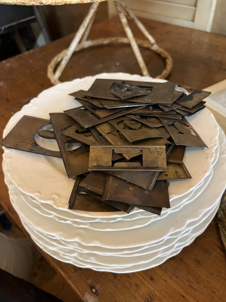 brass stencils piled on a stack of plates