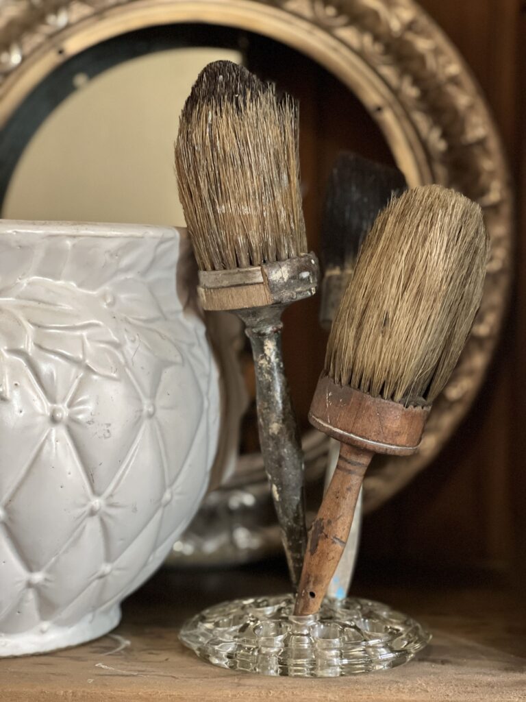 Brushes displayed in a glass flower frog