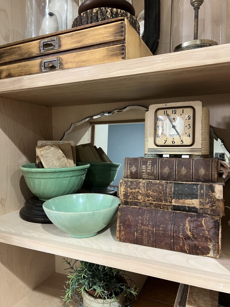 book stack with clock on top and green bowls