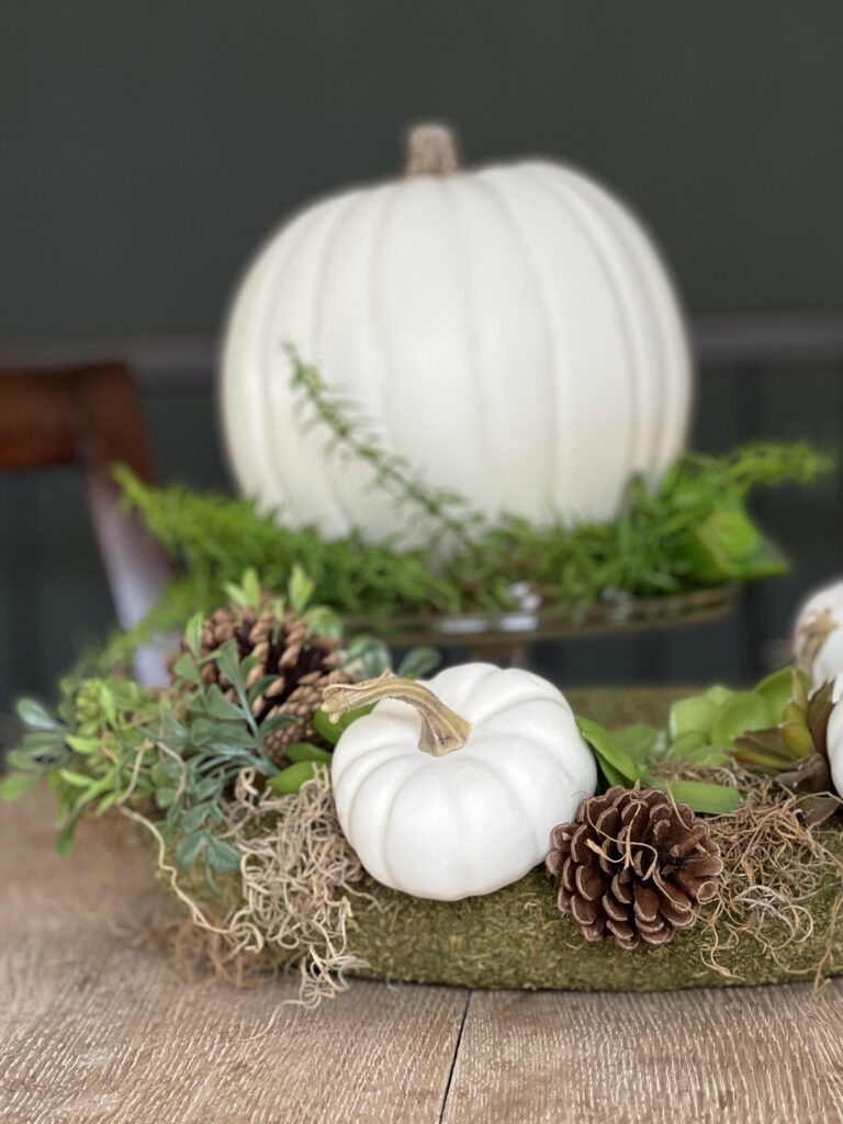 pumpkin and succulent wreath as a centerpiece with another pumpkin on a cake stand