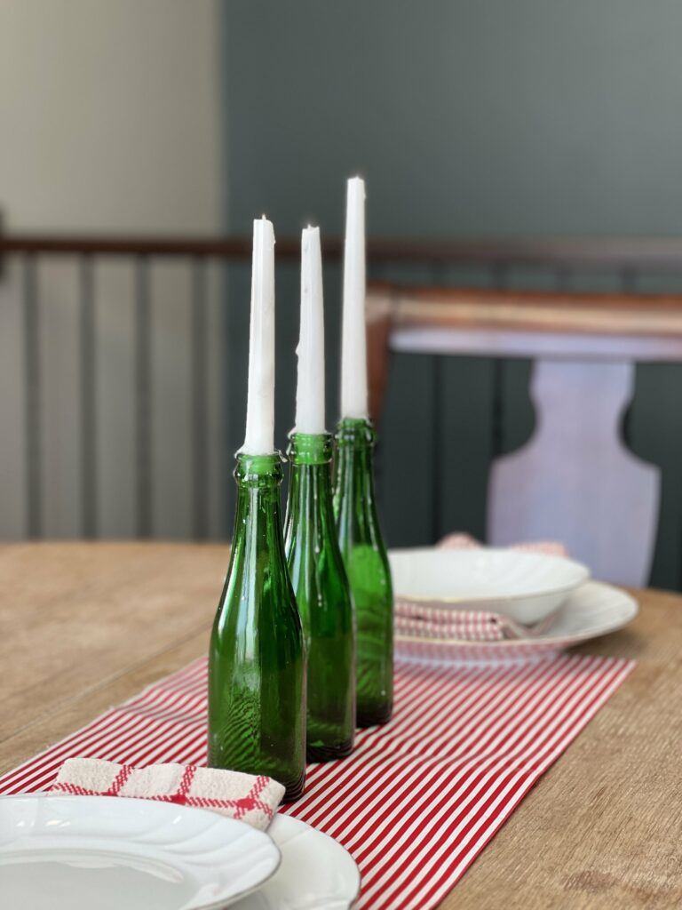 wrapping paper as a table runner with bottles as candle stick holders in the center