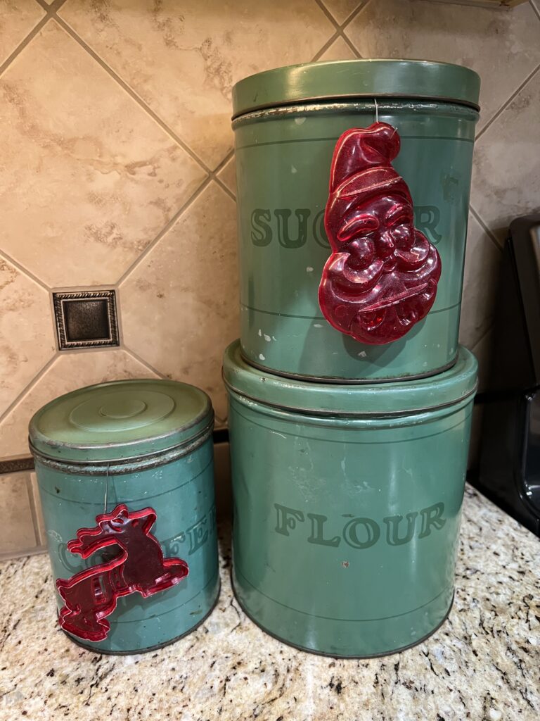 grandma's red plastic cookie cutters hanging on my green canisters