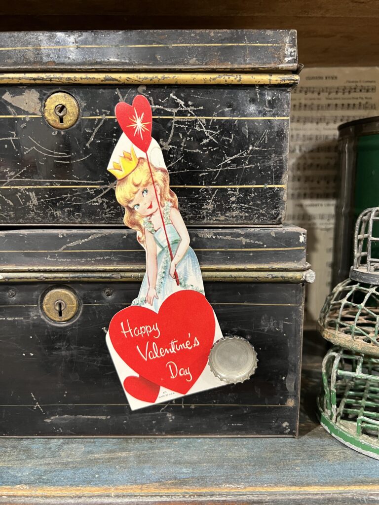 bottle top glued to a magnet that is stuck to money boxes holding a valentine
